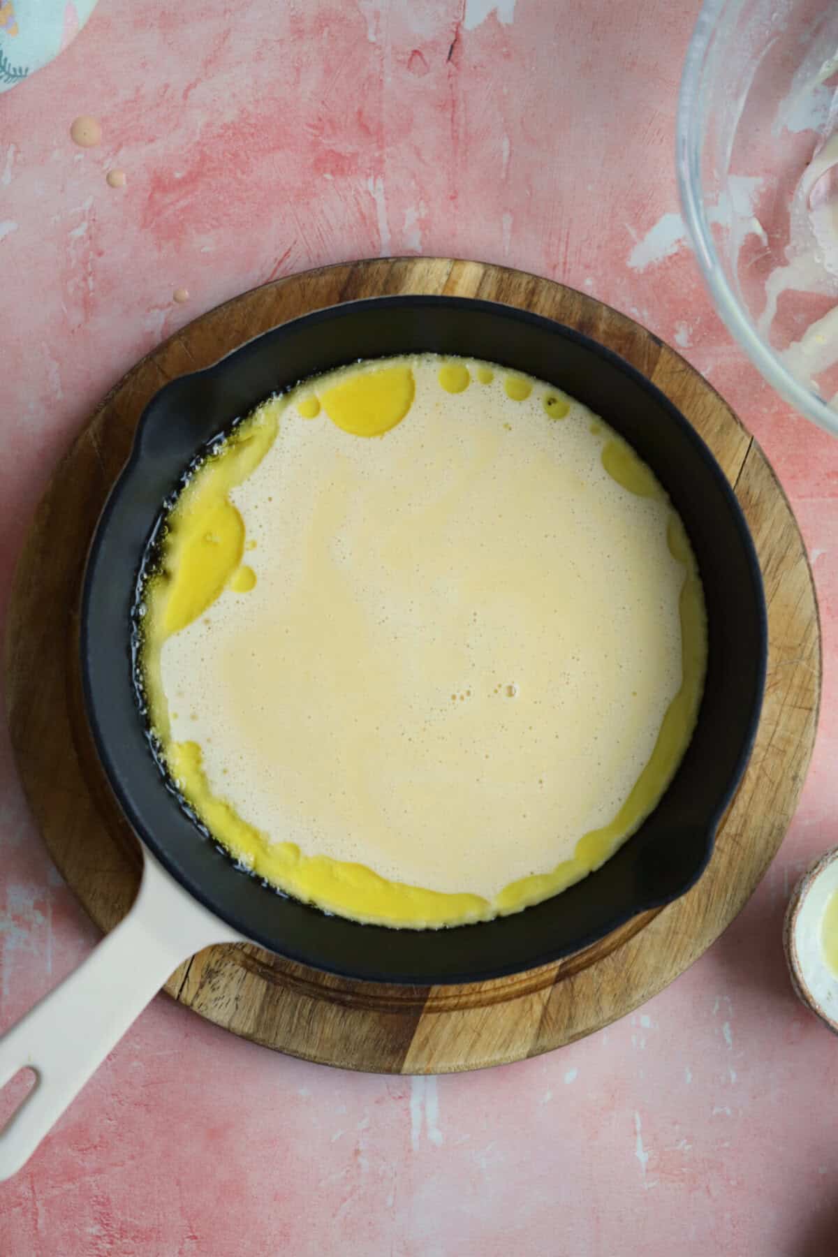 Process shot of gluten free socca recipe showing the batter poured into an oiled pan.