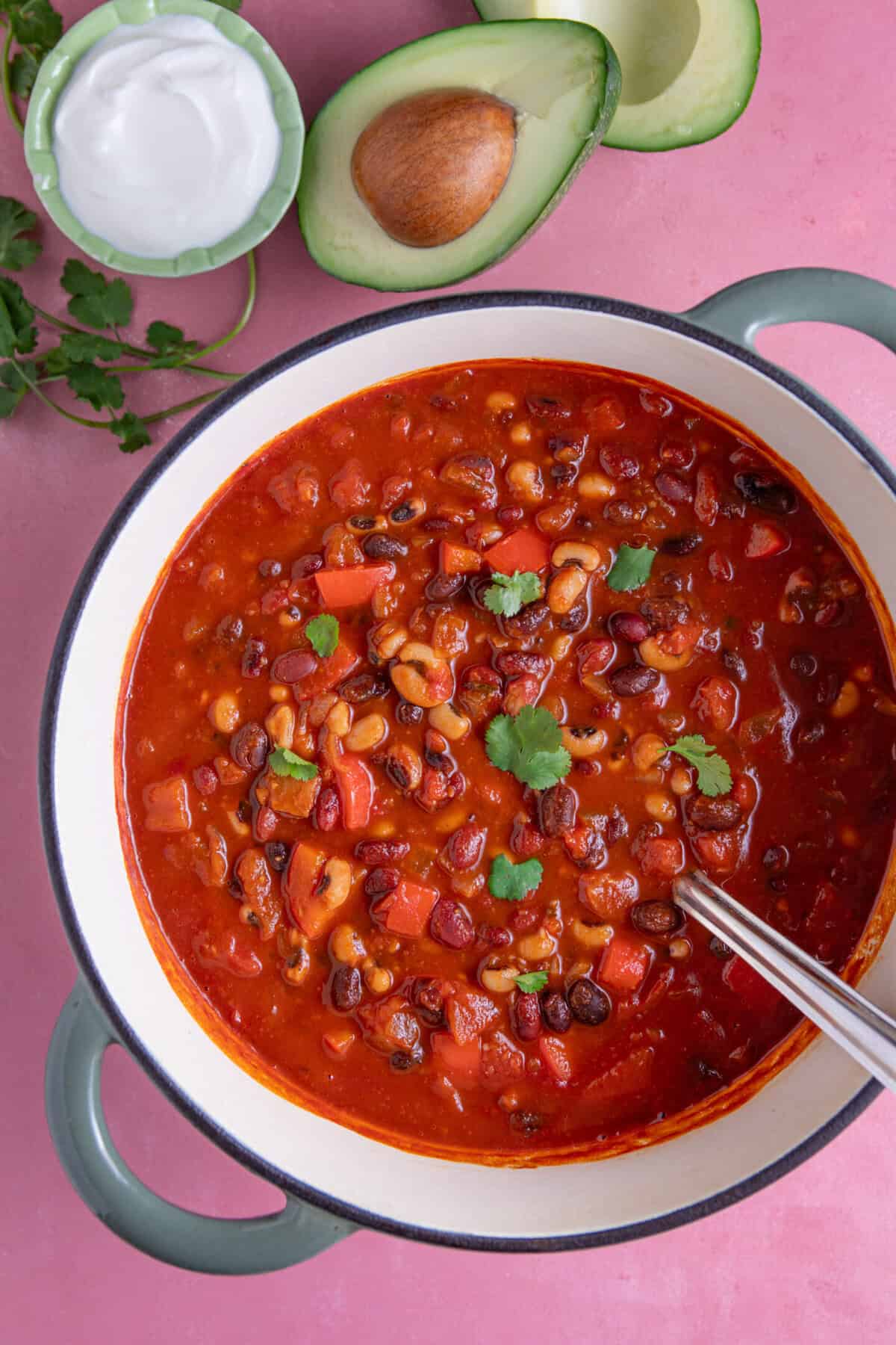 Process shot of a bean chilli recipe showing the finished bean chilli in a pan, garnished with some coriander.