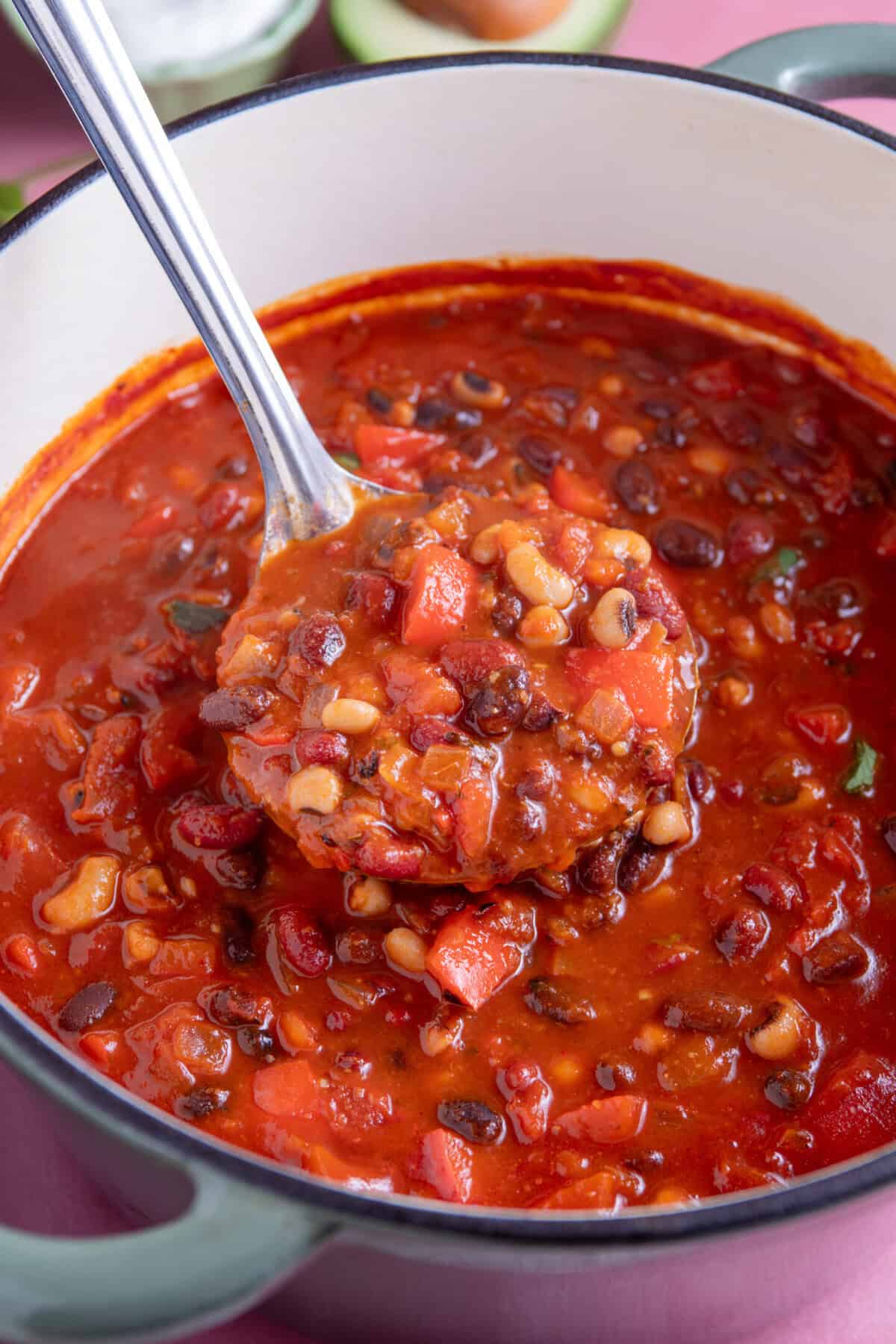 A pan of bean chilli with a ladle lifting out a portion.