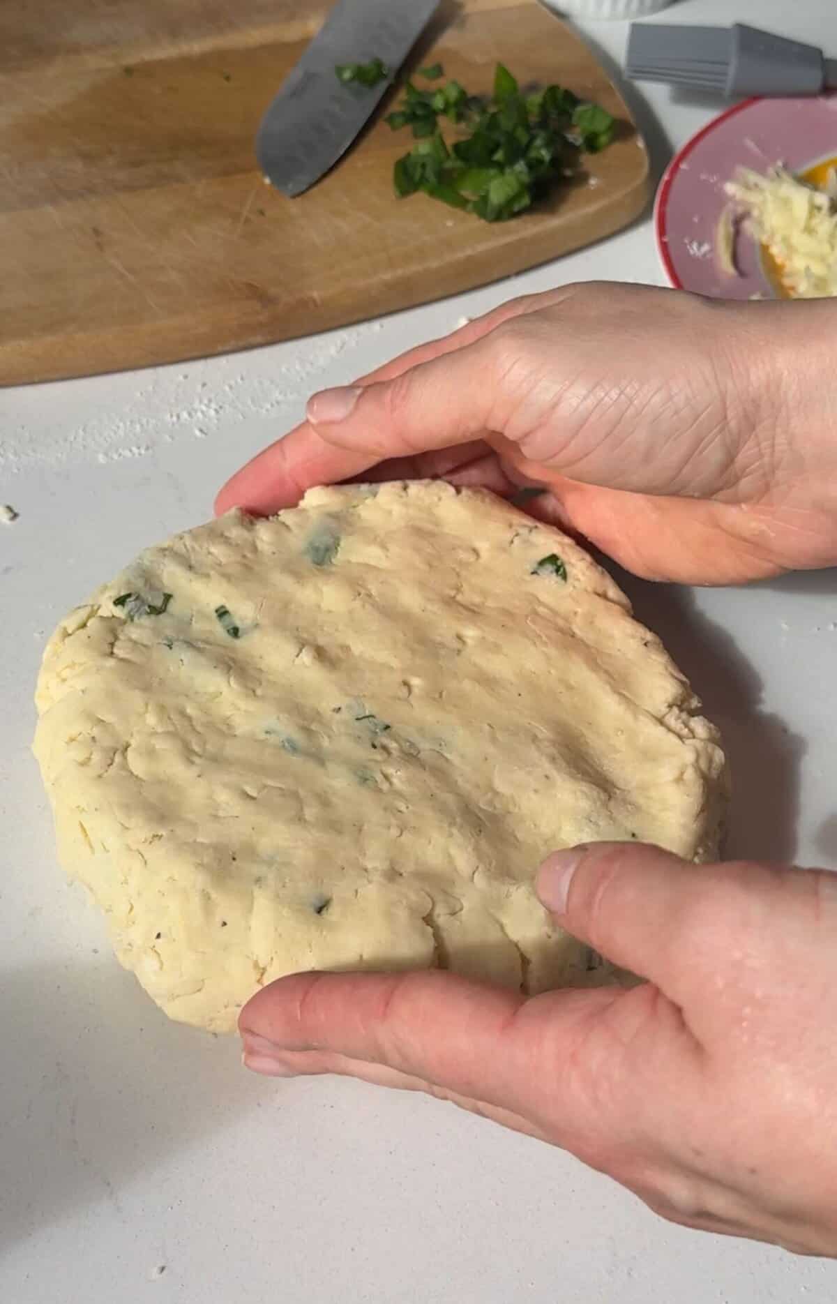 Process shot of cheese and wild garlic scones recipe showing the dough being shaped into a disc.