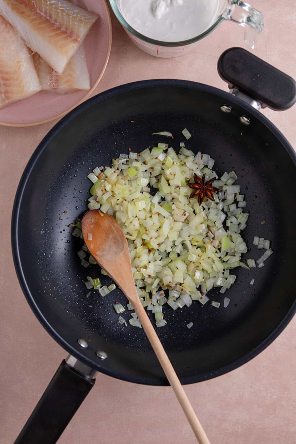 Onion, garlic, ginger and spices frying in a large pan.