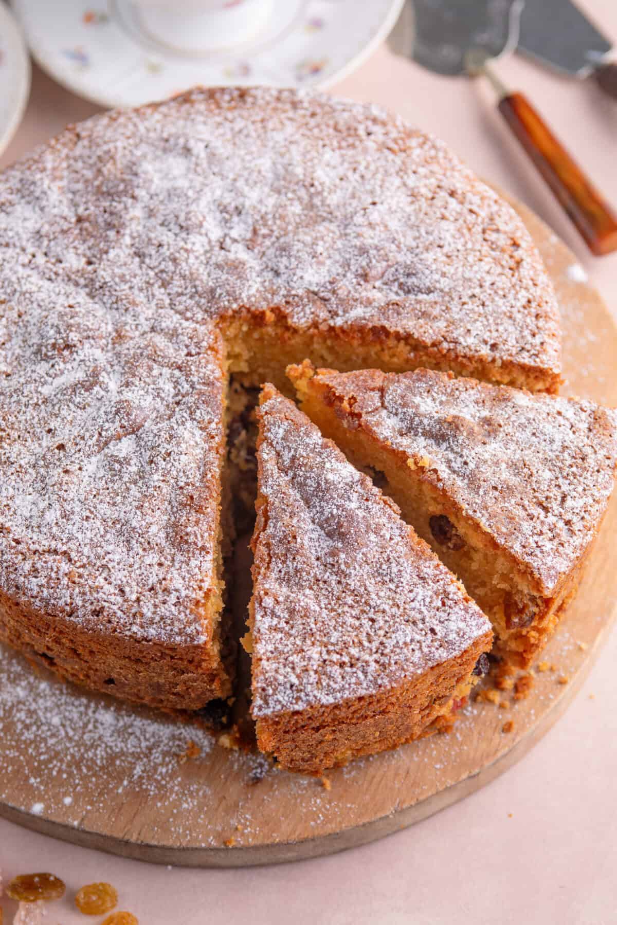 A gluten free fruit cake with two slices cut from it ready to serve.