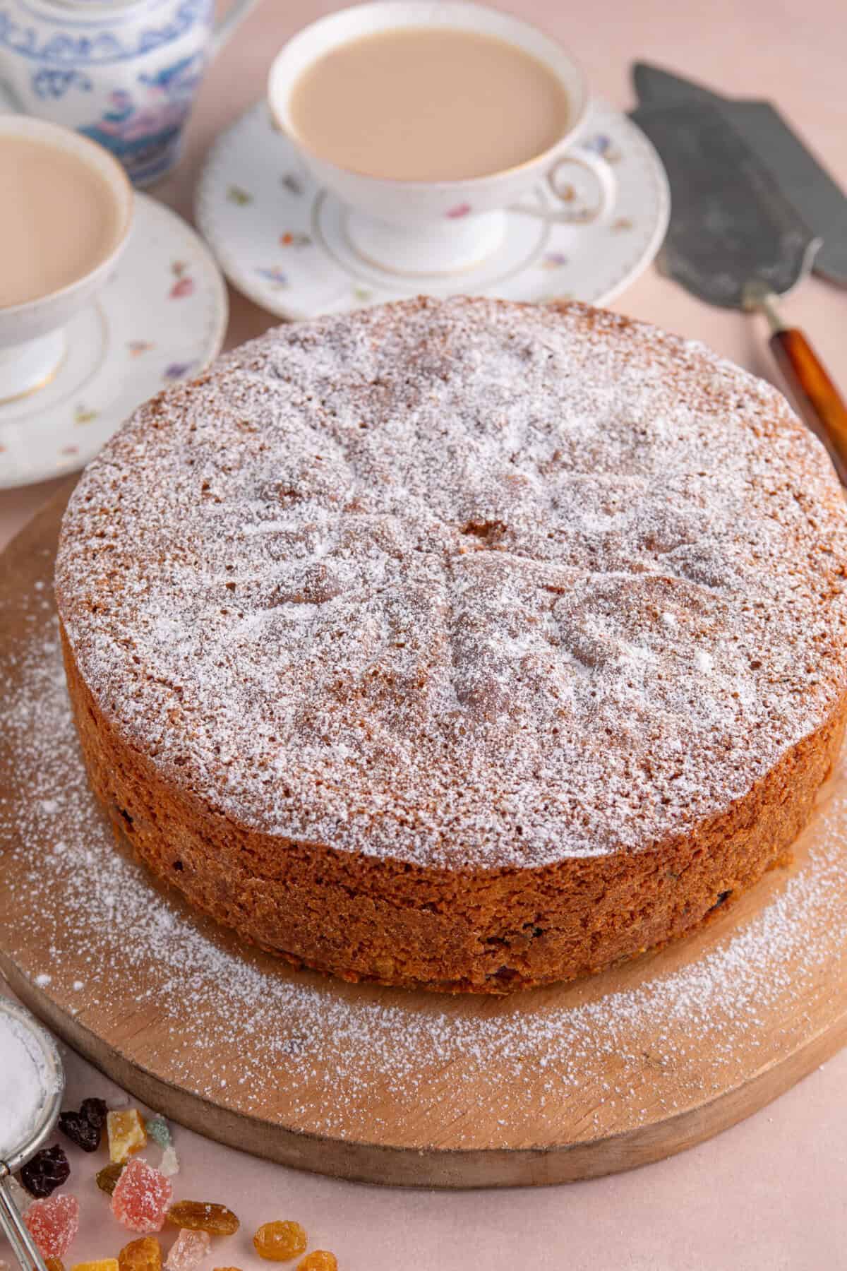 Process shot of a gluten free fruit cake recipe showing the finished cake on a board.