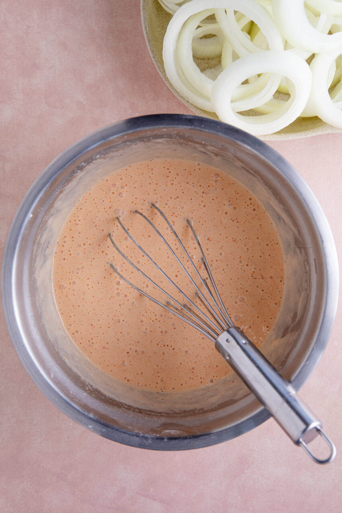 The batter for the onion rings in a bowl.
