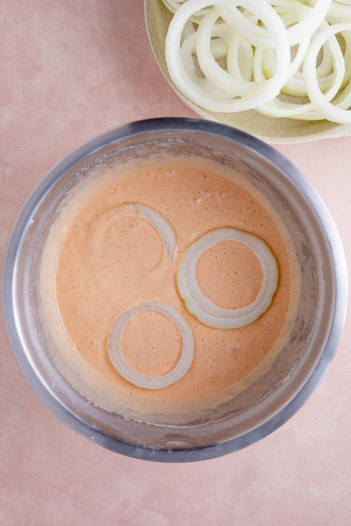 Rings of onion in the batter ready to fry.