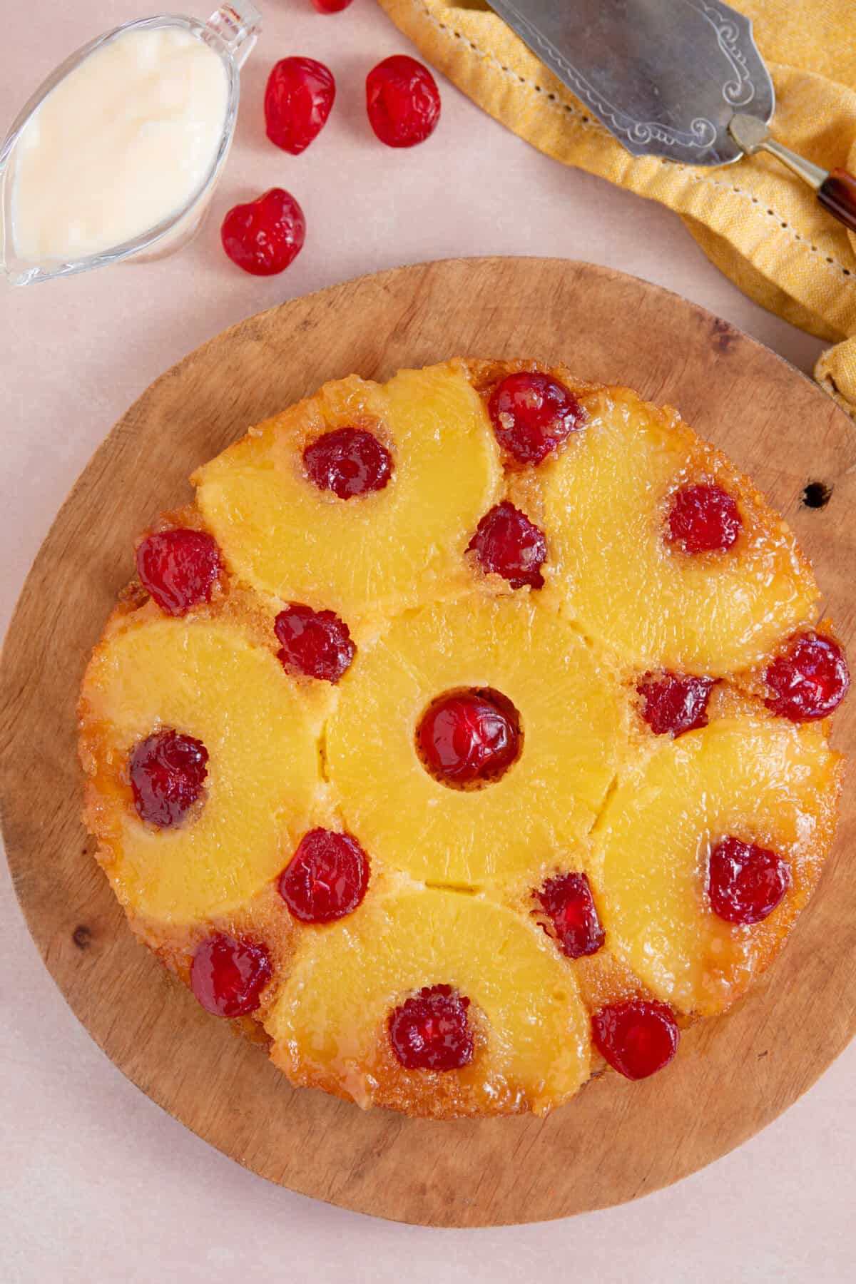 Process shot of a pineapple upside down cake showing the finished cake turned out onto a serving board.