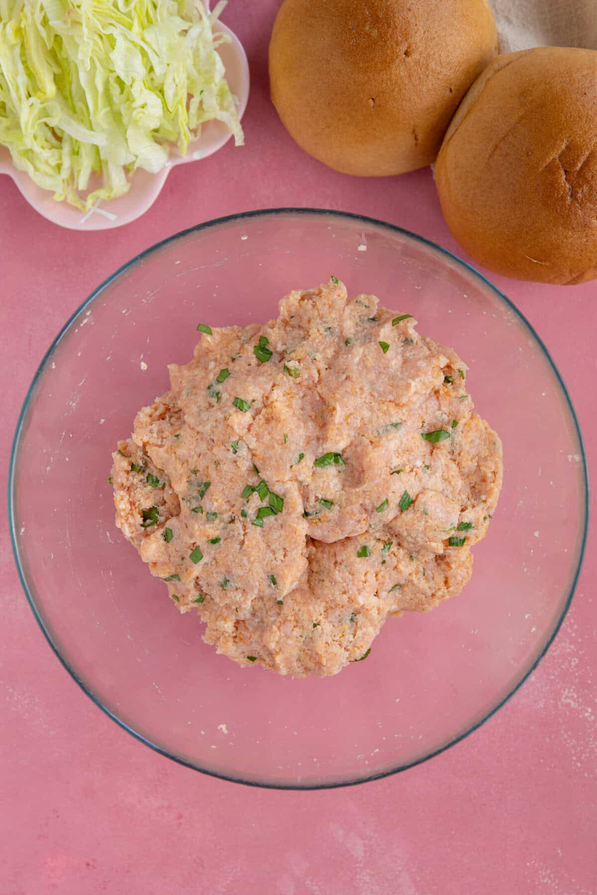 Process shot for chicken mince burgers showing the mixture combined together in a glass bowl.