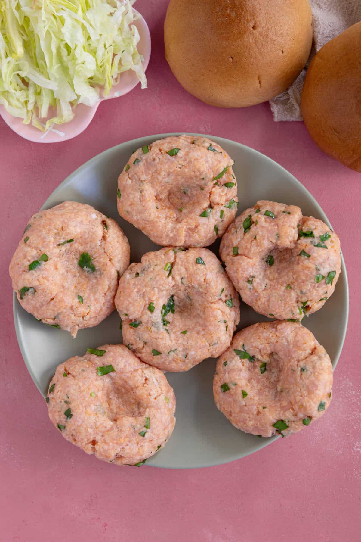 Process shot for chicken mince burgers showing the mixture formed into patties with a thumbprint in the centre.