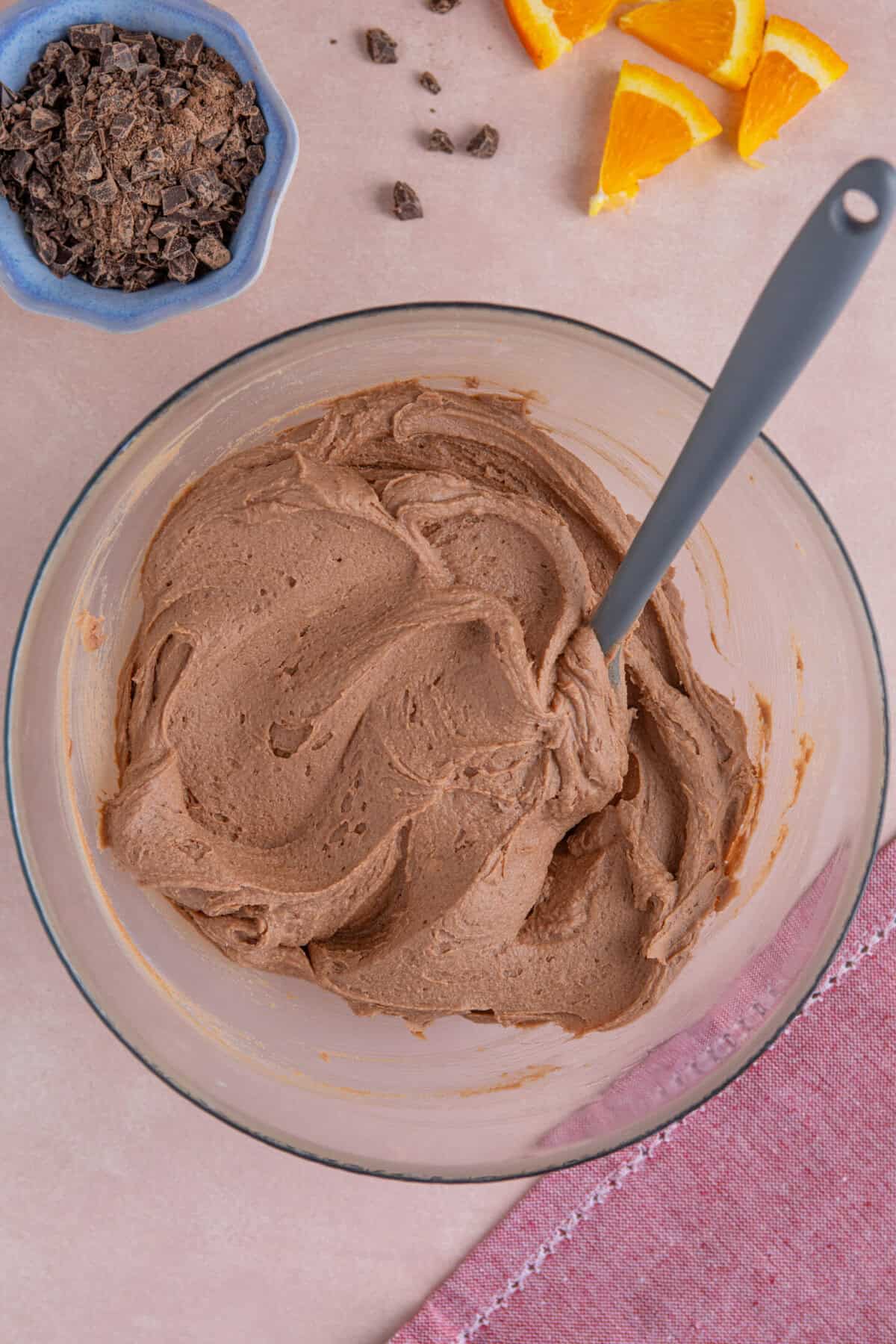 Process shot of gluten free chocolate orange cupcakes showing the buttercream frosting in a bowl.