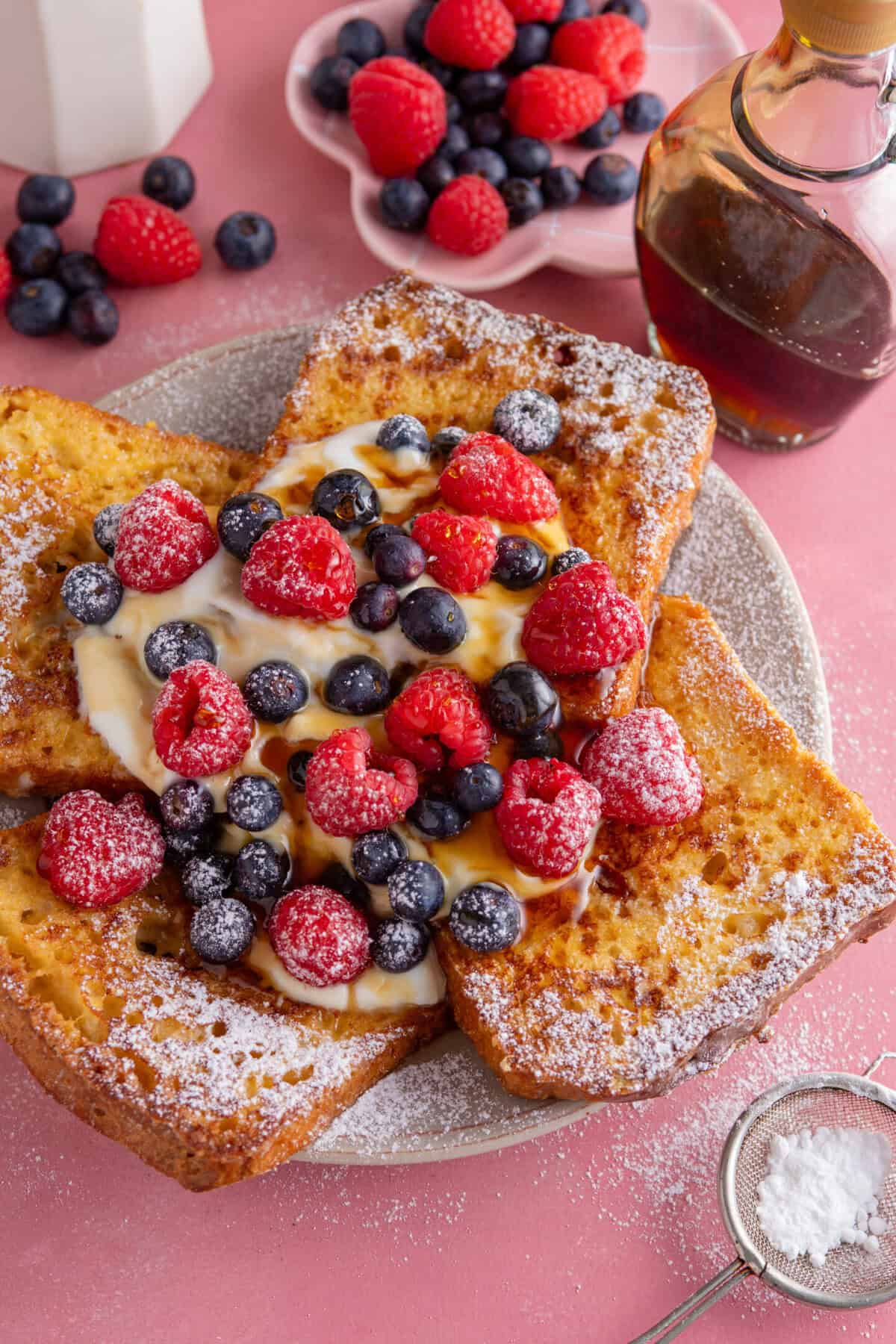 A plate of gluten free French toast with yoghurt and berries on top.