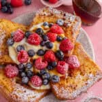 A plate of gluten free French toast with yoghurt and berries on top.