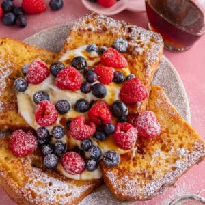 A plate of gluten free French toast with yoghurt and berries on top.