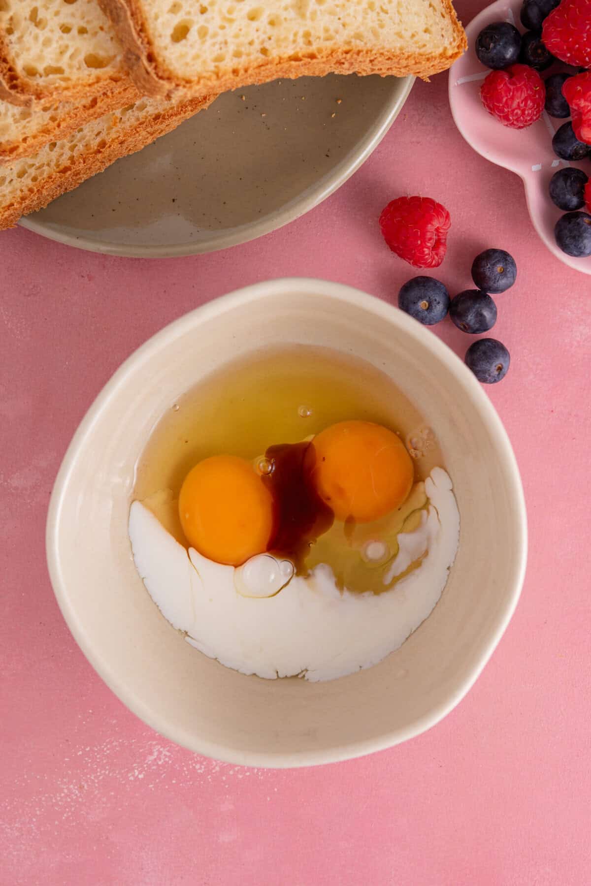 Process shot of gluten free French toast showing the eggs, milk and vanilla extract in a bowl.
