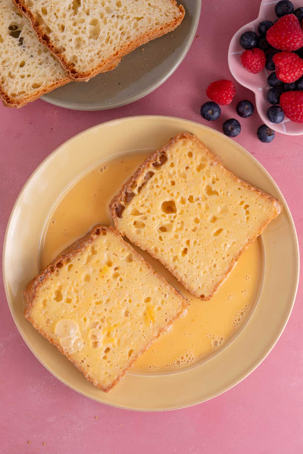 Process shot of gluten free French toast showing the bread being dipped into the egg mixture.