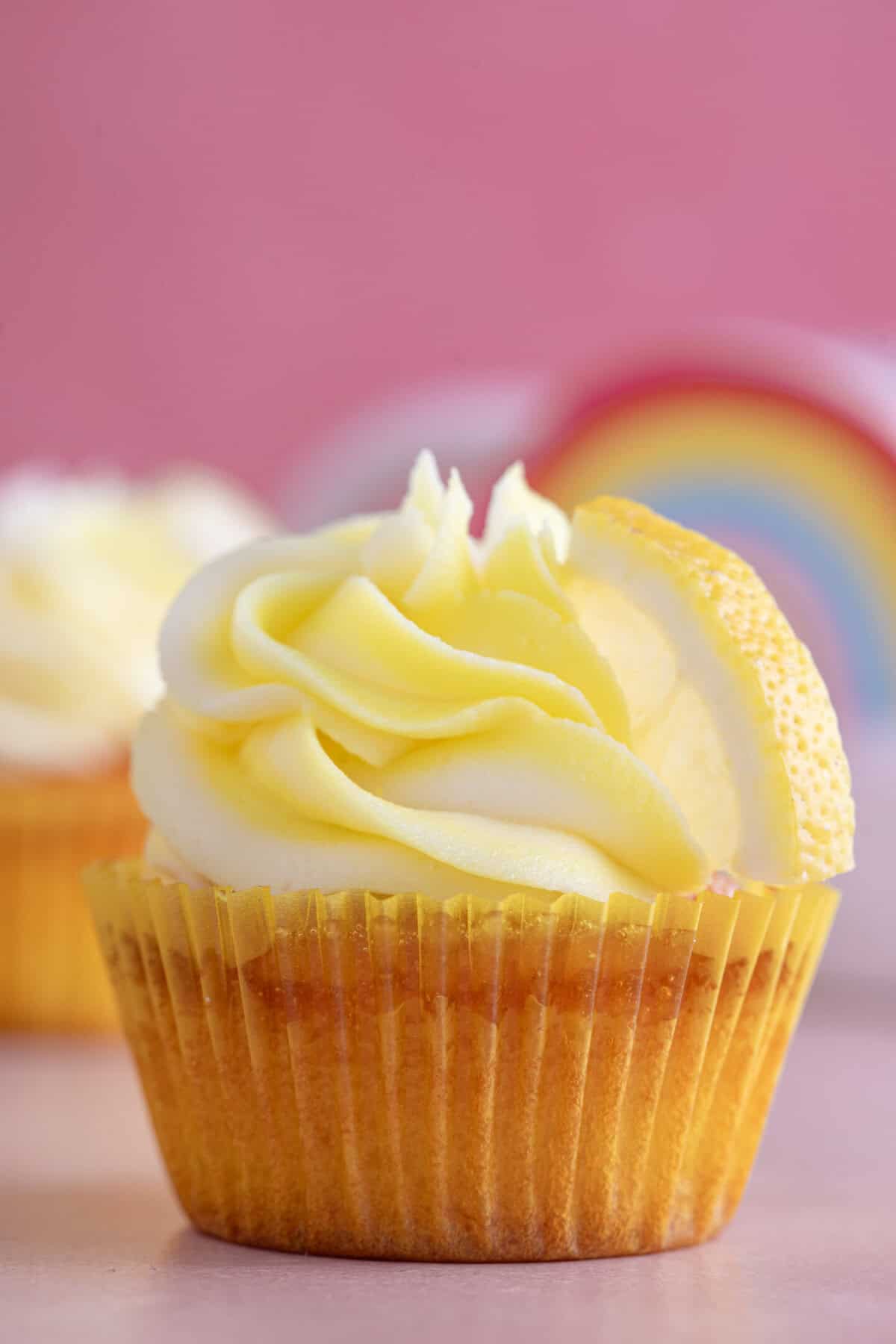 Process shot for gluten free lemon drizzle cupcakes showing the finished cupcake with frosting.