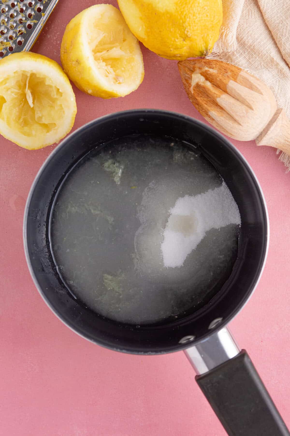 Process shot for gluten free lemon drizzle cupcakes showing the ingredients for the lemon syrup in a pan.