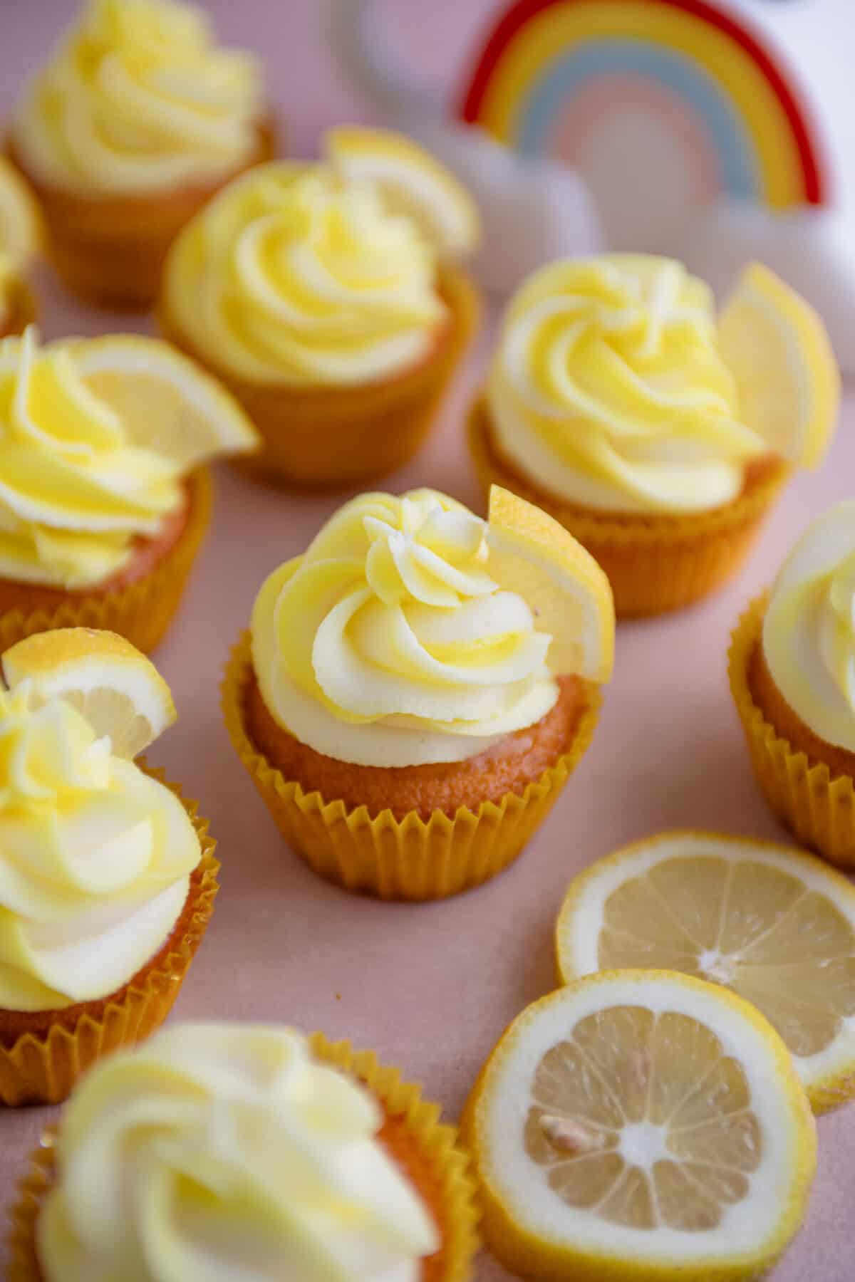 Gluten free lemon cupcakes in yellow cake cases with a swirl of yellow and white buttercream.
