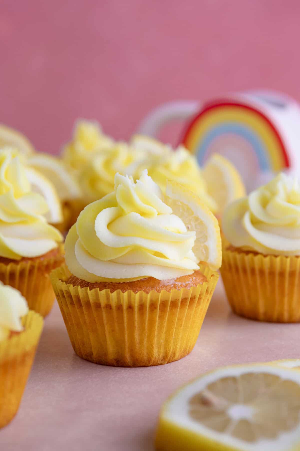 Gluten free lemon cupcakes in yellow cake cases with a swirl of yellow and white buttercream.