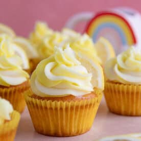 Gluten free lemon cupcakes in yellow cake cases with a swirl of yellow and white buttercream.