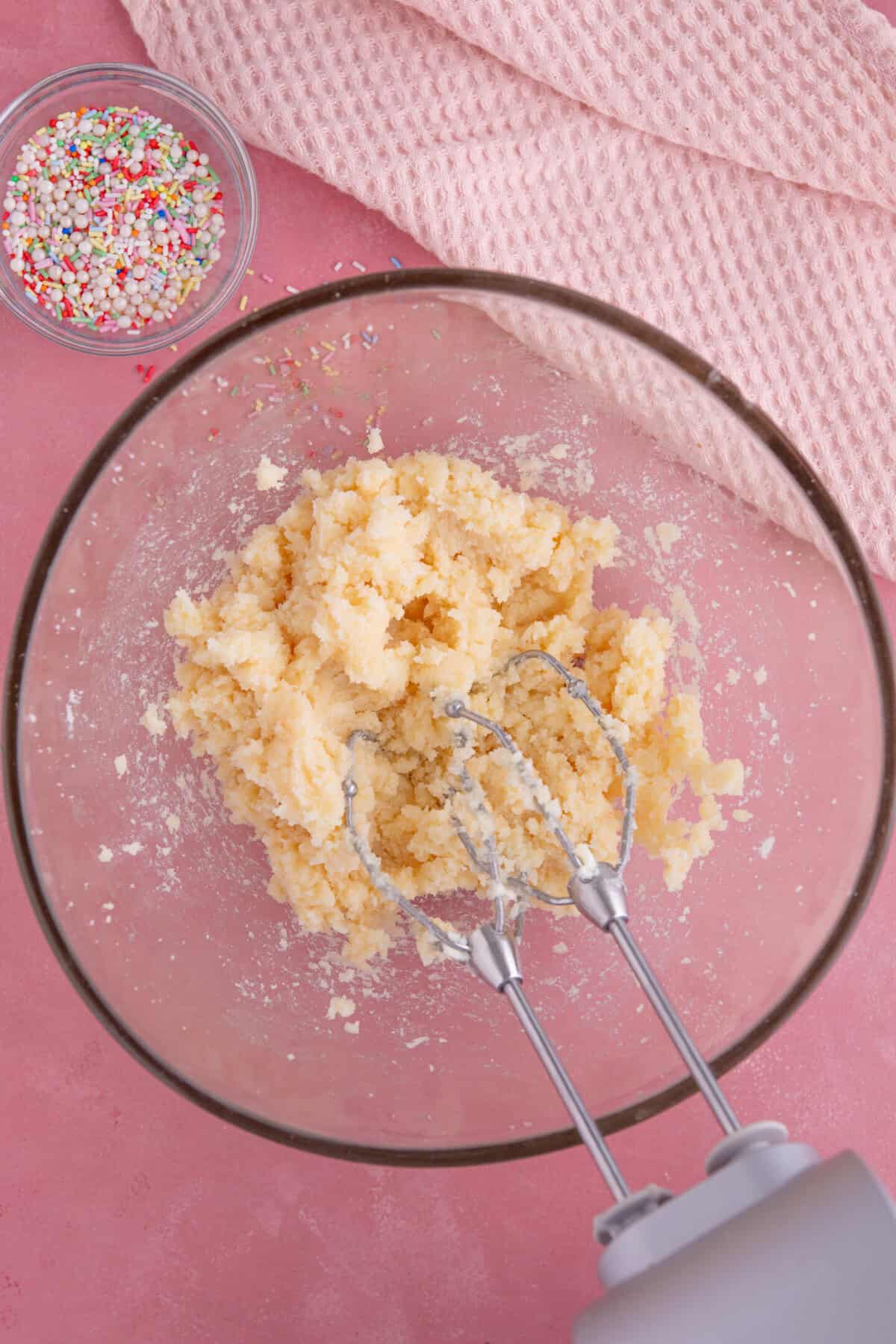 Process shot of gluten free vanilla cupcakes showing the butter and sugar beaten together in a glass bowl.