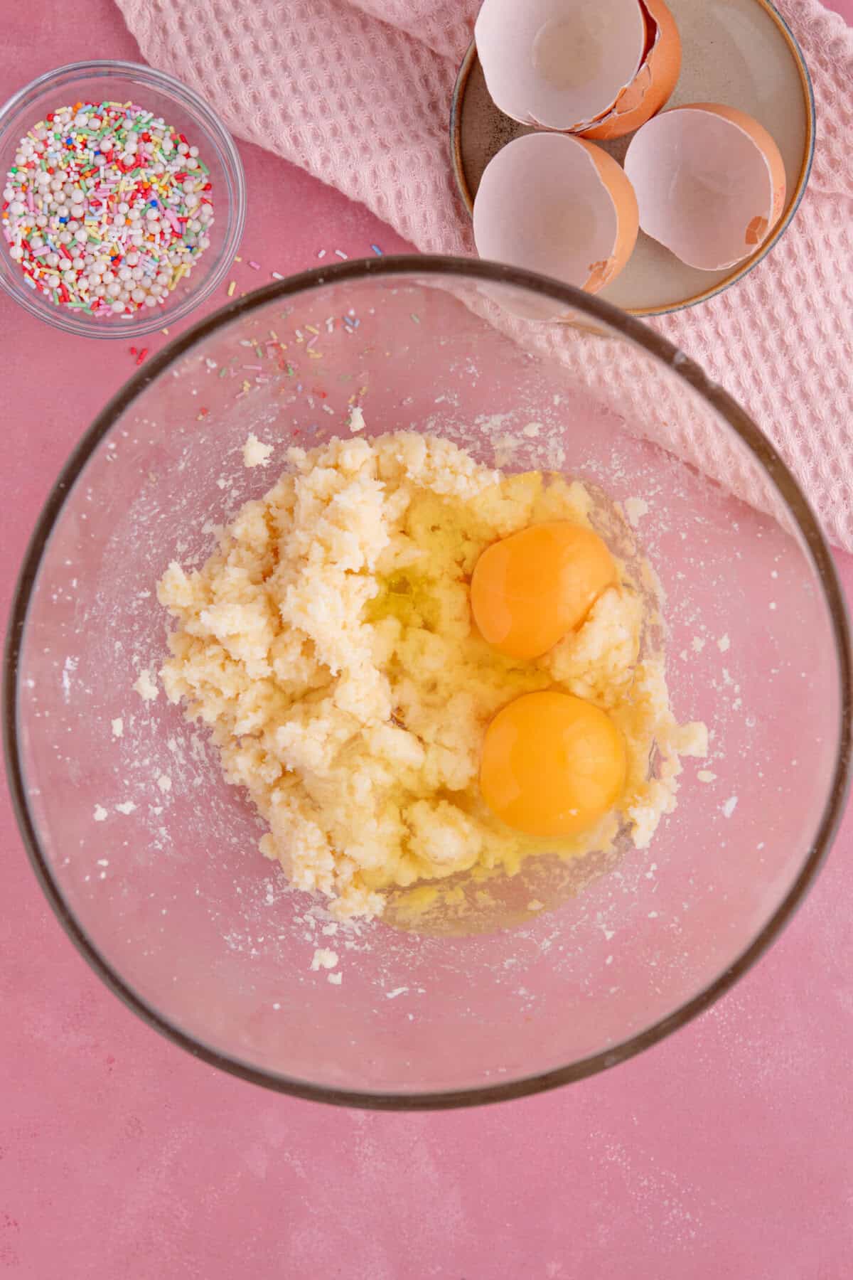 Process shot of gluten free vanilla cupcakes showing the eggs added to the butter and sugar.