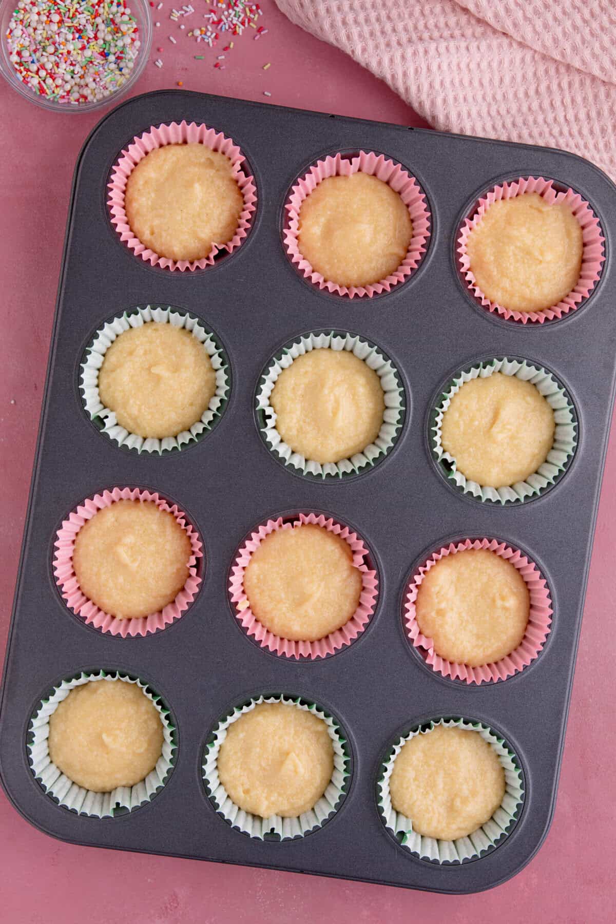 Process shot of gluten free vanilla cupcakes showing the unbaked cupcake batter in cupcake cases.