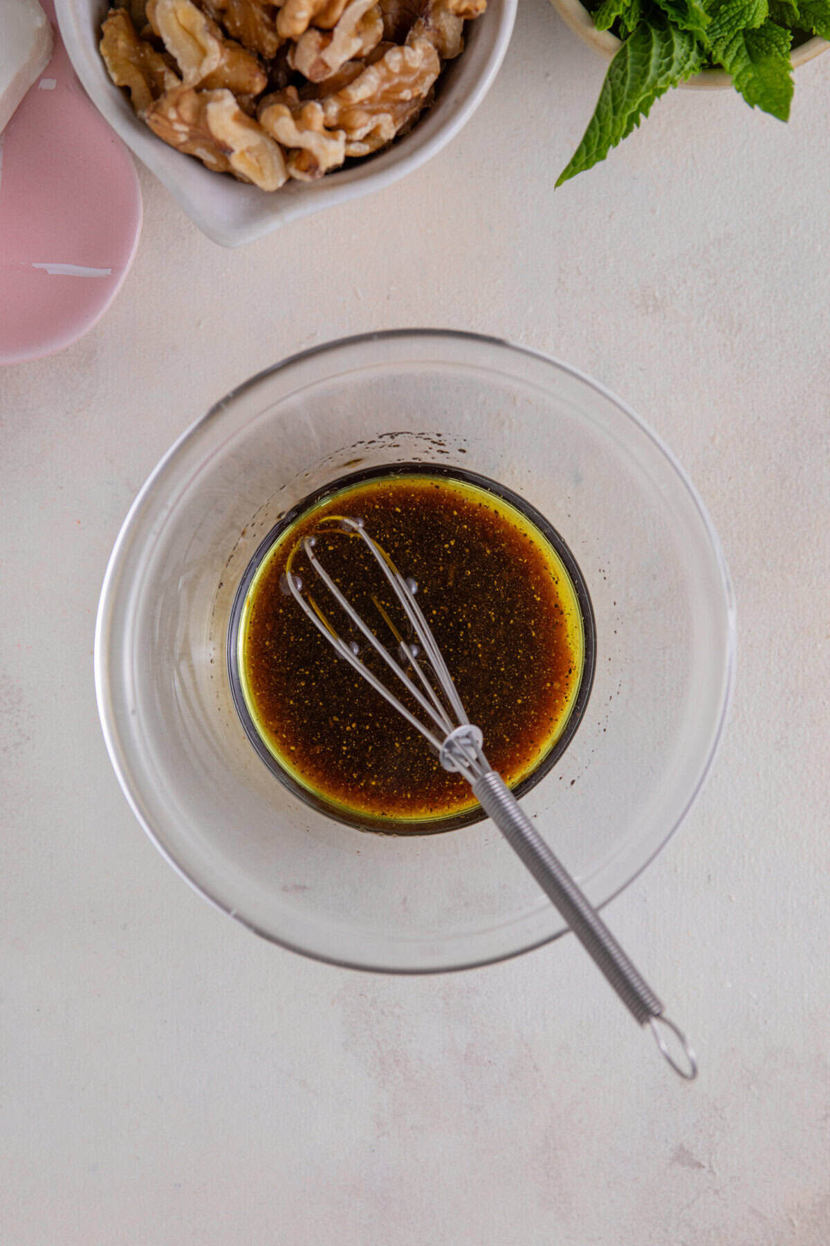 Process shot of beetroot salad recipe showing the salad dressing being mixed in a small glass bowl.