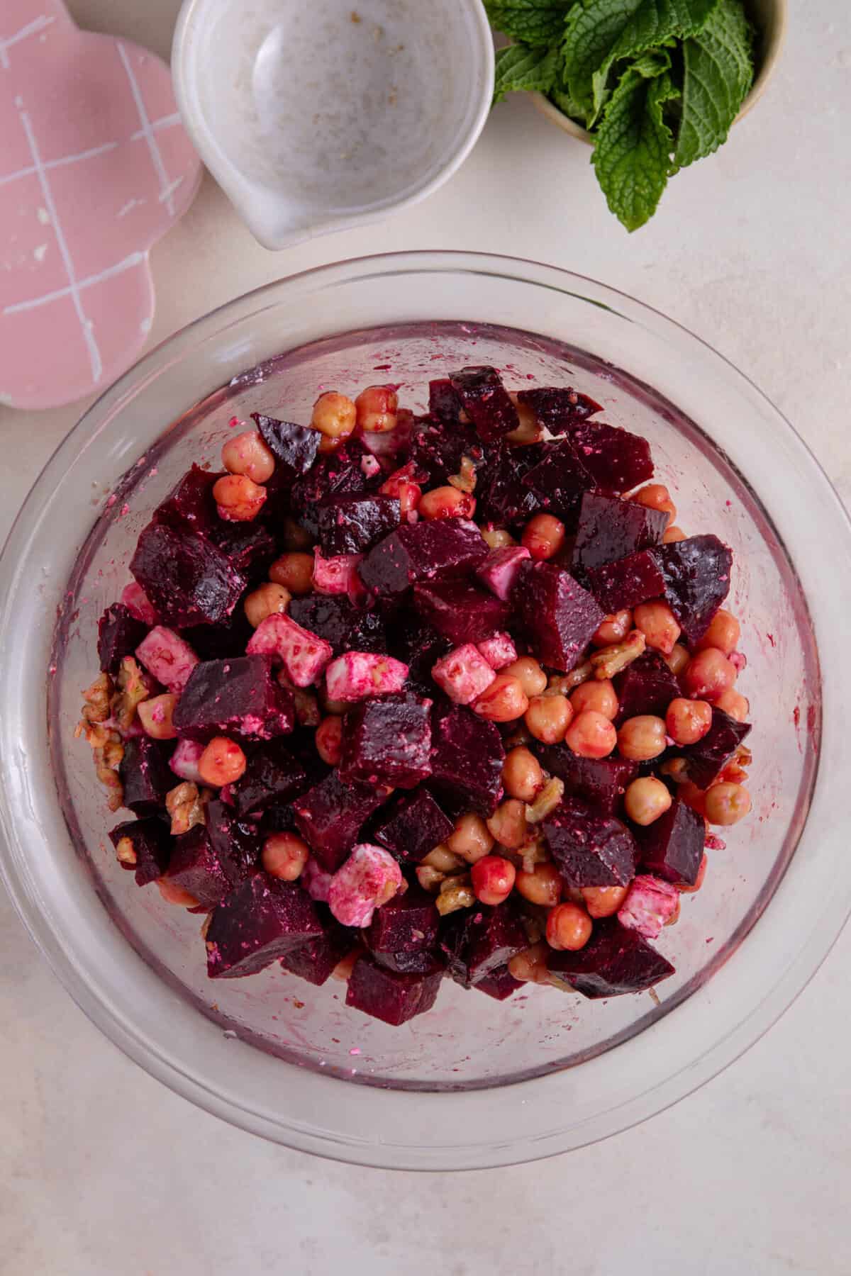 Process shot of beetroot salad recipe showing everything mixed together in a bowl.