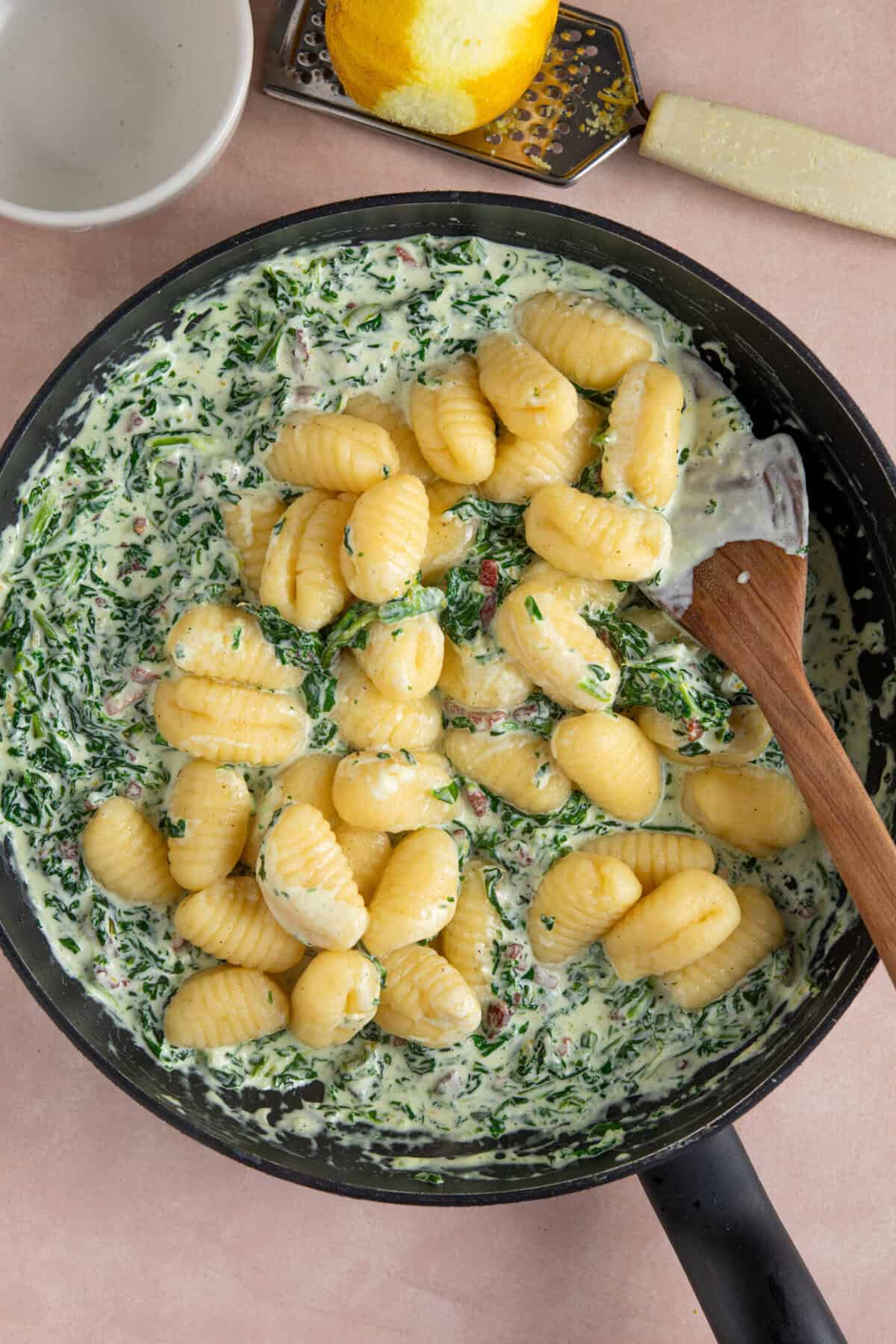 Process shot of creamy gnocchi recipe showing the cooked gnocchi added to the sauce.