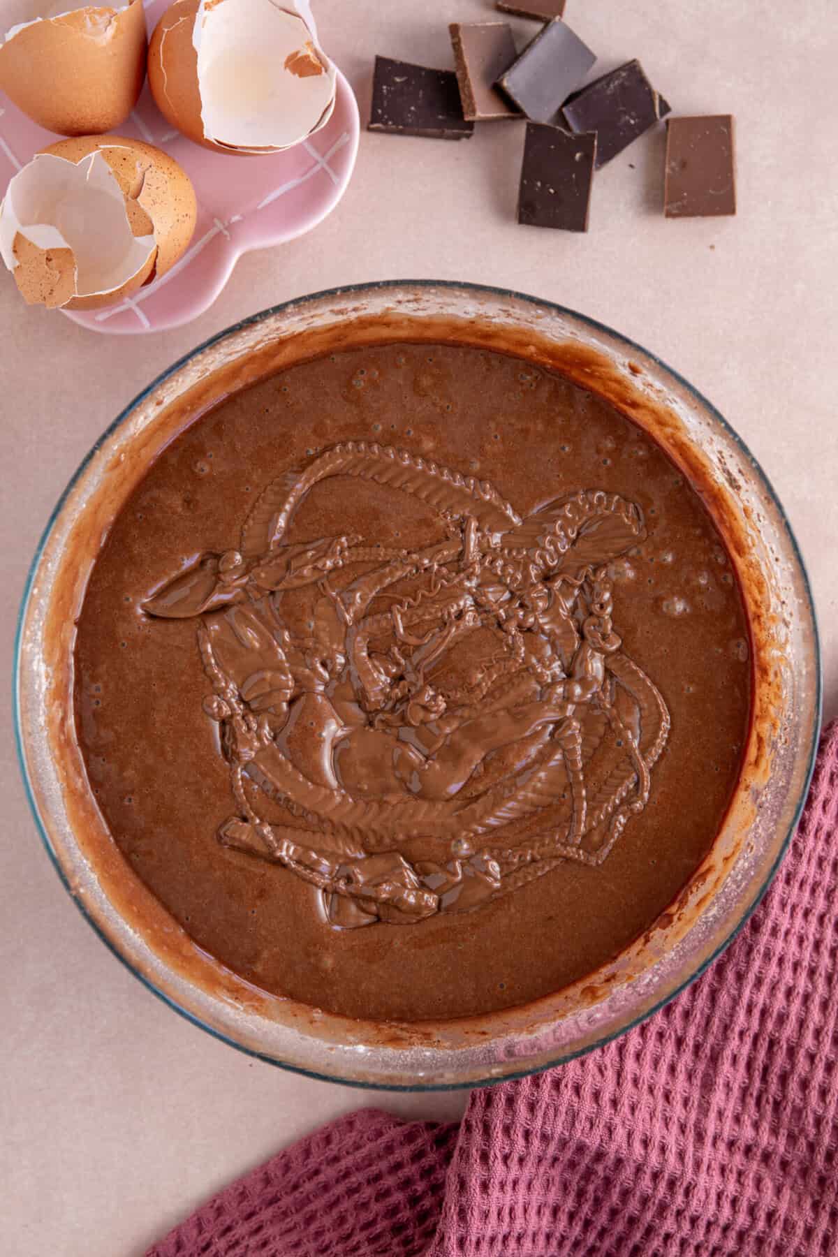 Process shot of a gluten free chocolate loaf cake recipe showing the chocolate cake batter in a glass bowl.