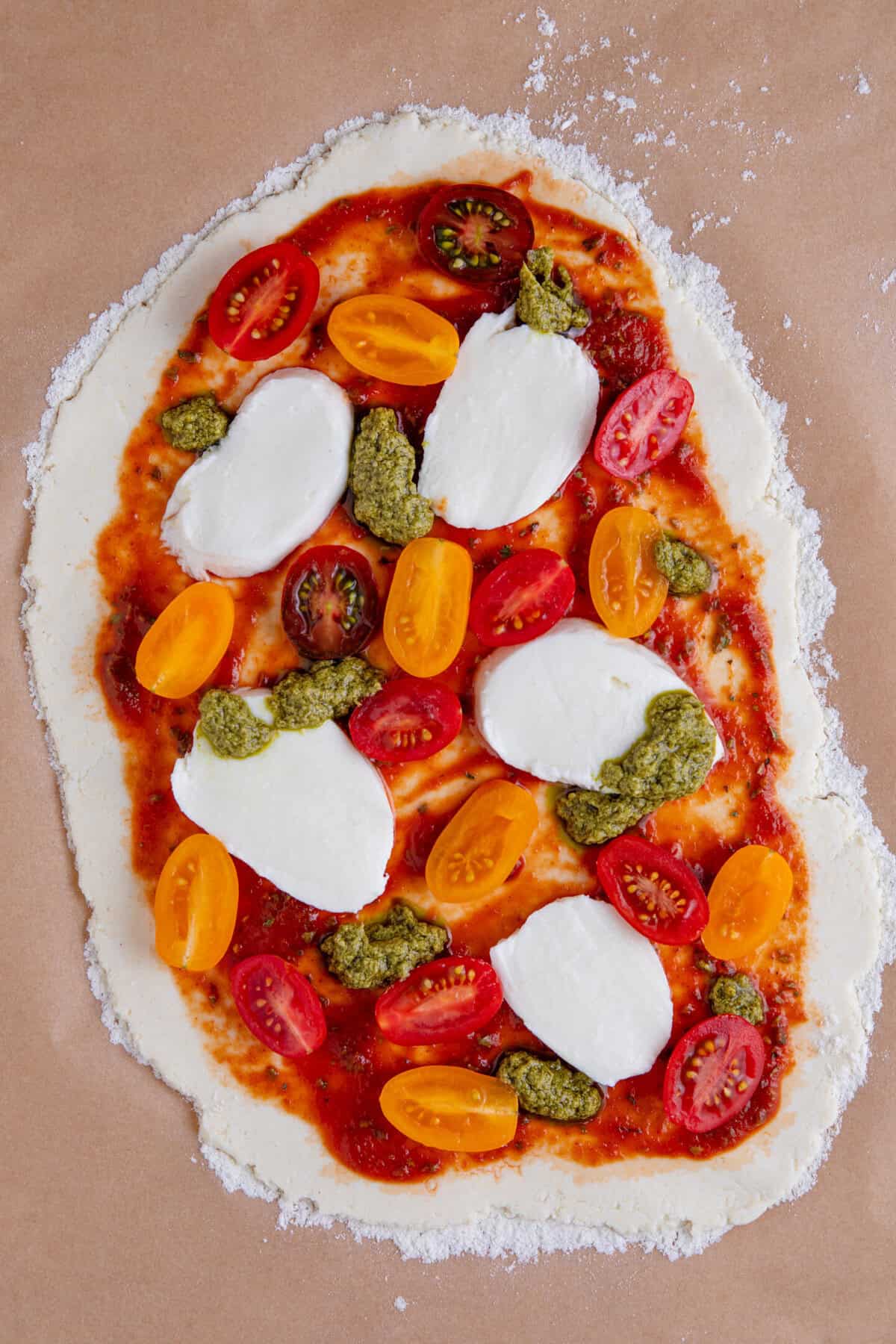 Process shot of gluten free flatbread pizza recipe showing the topped pizza ready to bake.