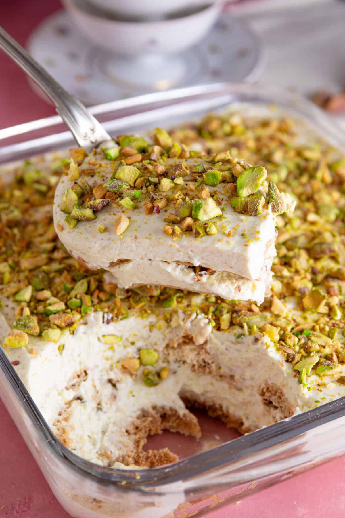 A gluten free pistachio tiramisu with a portion taken out of it, showing the layers.