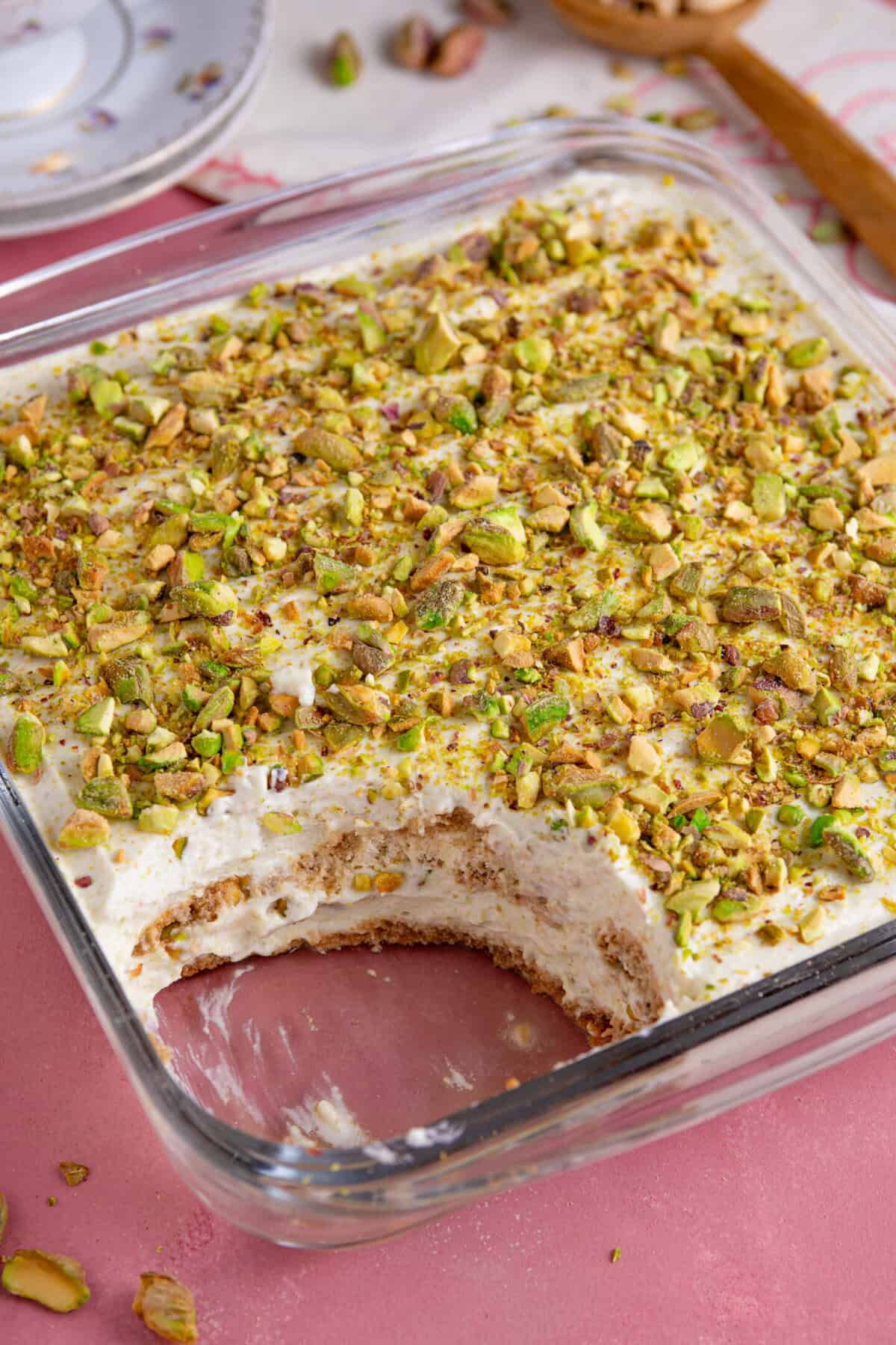 A gluten free pistachio tiramisu with a portion taken out of it, showing the layers.