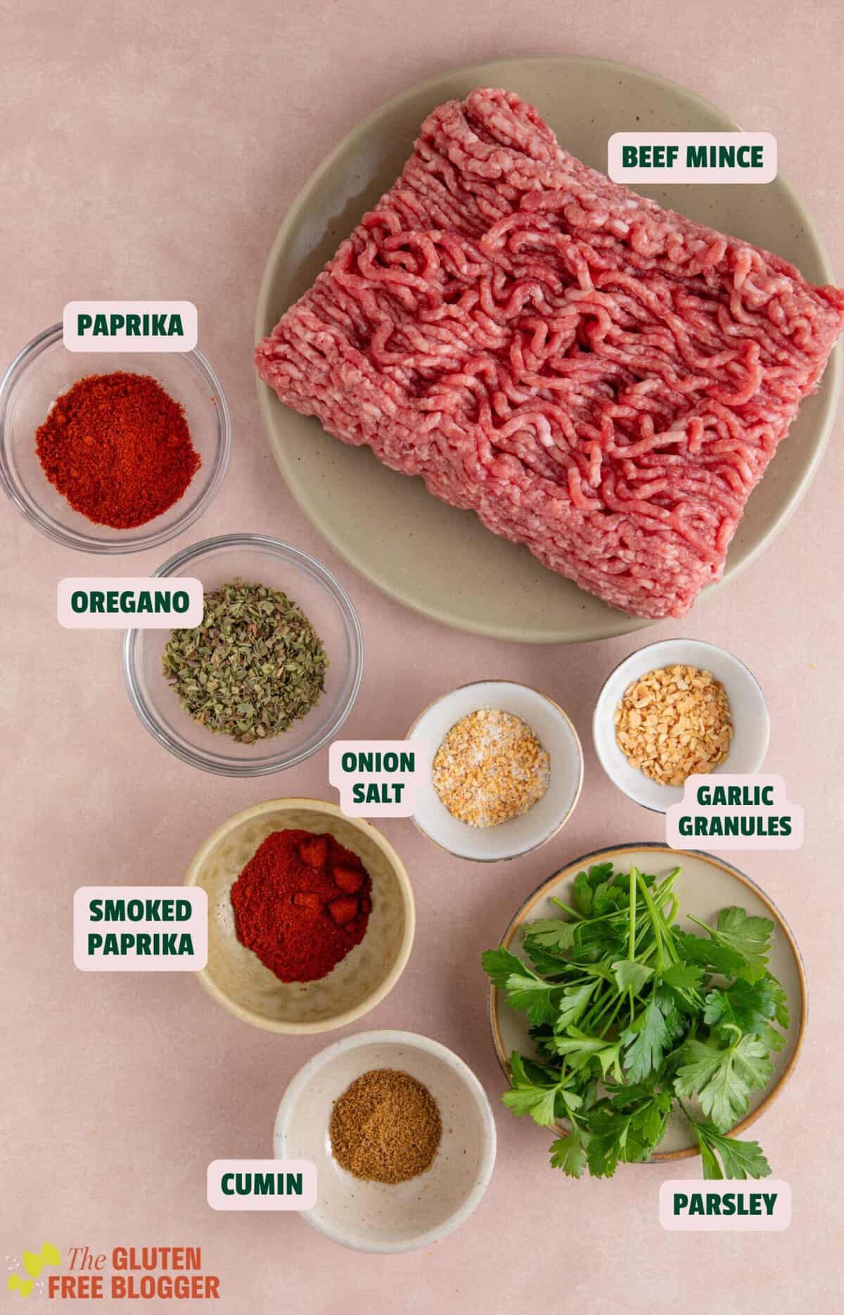 Flat lay of ingredients for sheet pan kebabs including minced beef, herbs and spices.
