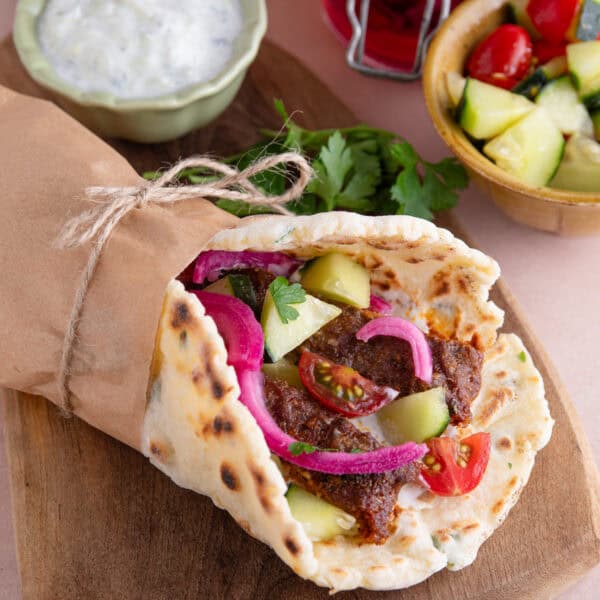 A gluten free kebab made with the viral sheet pan kebab, a gluten free flatbread, cucumber, red onion and tomatoes.