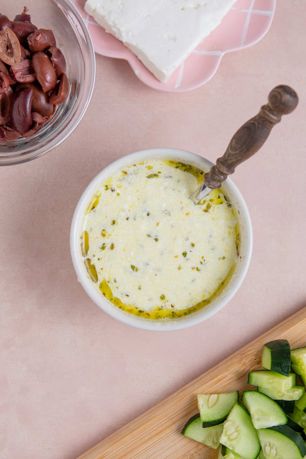 Process shot of a Greek pasta salad recipe showing the dressing mixed up in a small bowl.