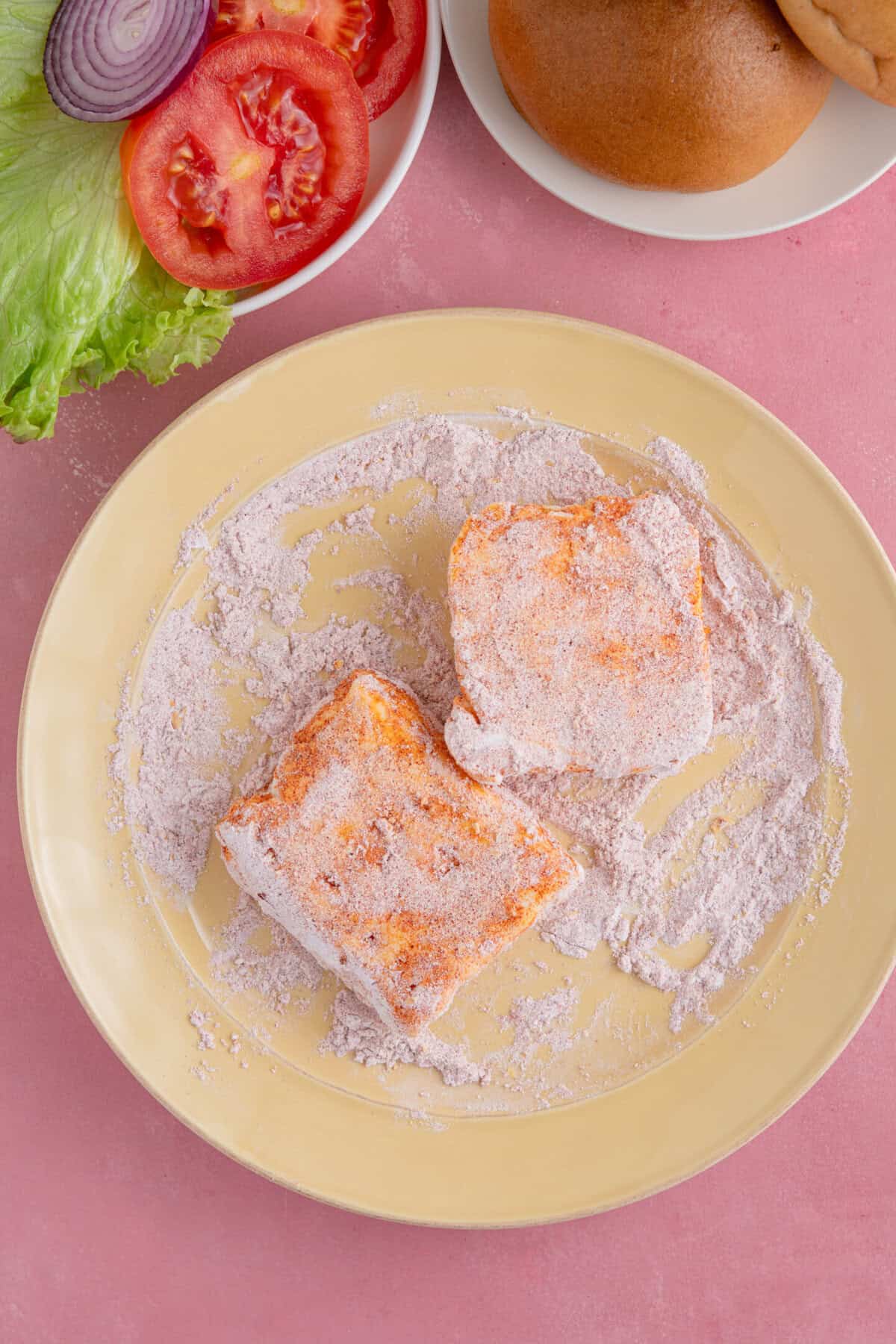 Process shot of gluten free halloumi burgers showing coating the halloumi slices in flour.