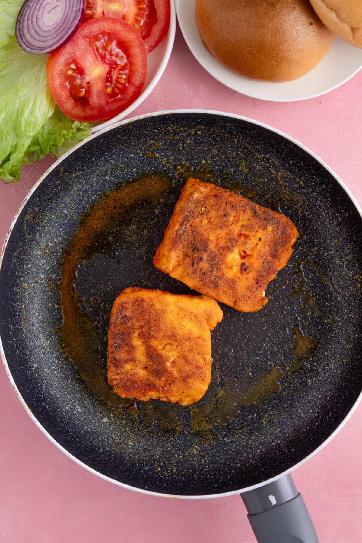 Process shot of gluten free halloumi burgers showing the halloumi frying in a pan.