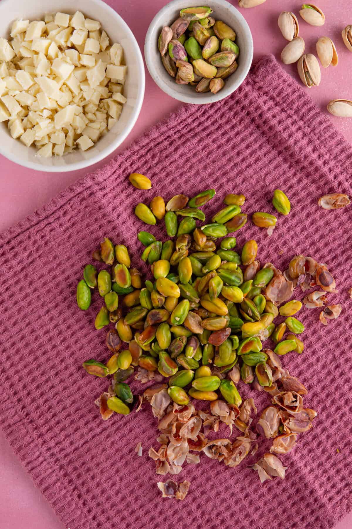 Process shot for pistachio spread recipe showing the nuts in a tea towel, with the skins removed.