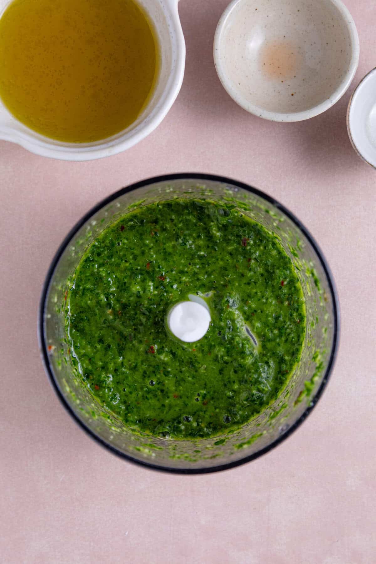 Process shot of chimichurri smashed potatoes recipe showing the chimichurri sauce in a blender.