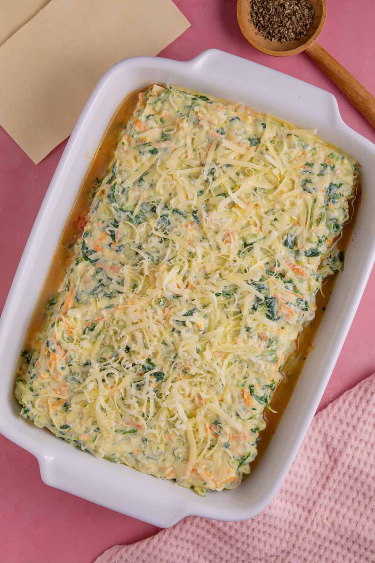 Gluten free courgette lasagne recipe process shot showing the finished lasagne topped with cheese ready to bake.