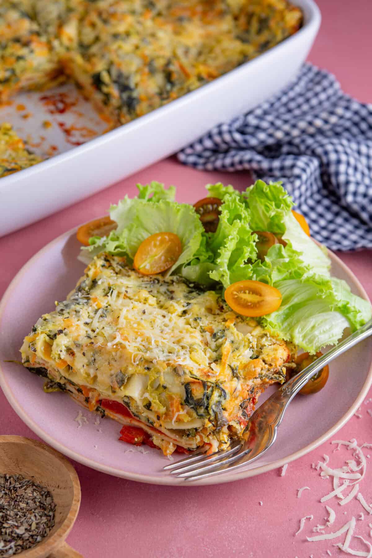 A serving of gluten free courgette lasagne with a side of salad.