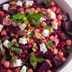 Close up of a beetroot, feta and walnut salad with fresh mint.