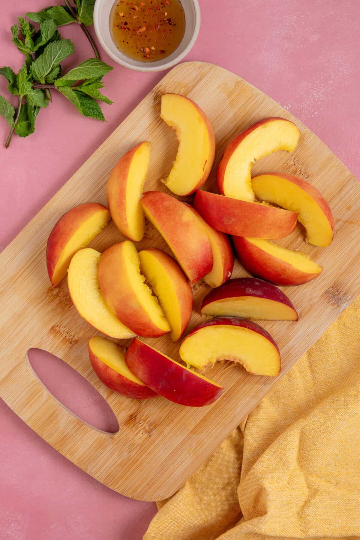 Process shot of peach and halloumi salad recipe showing the peaches cut into wedges.