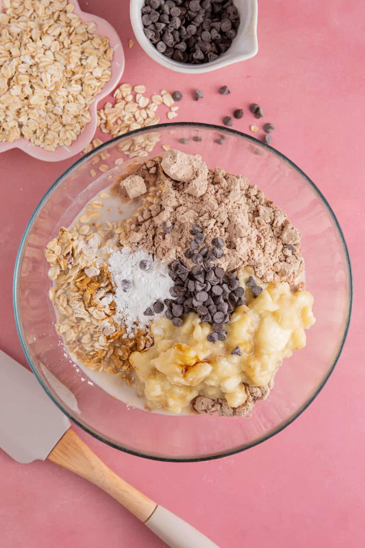 Process shot of banana baked oats showing all the ingredients added to a glass mixing bowl.