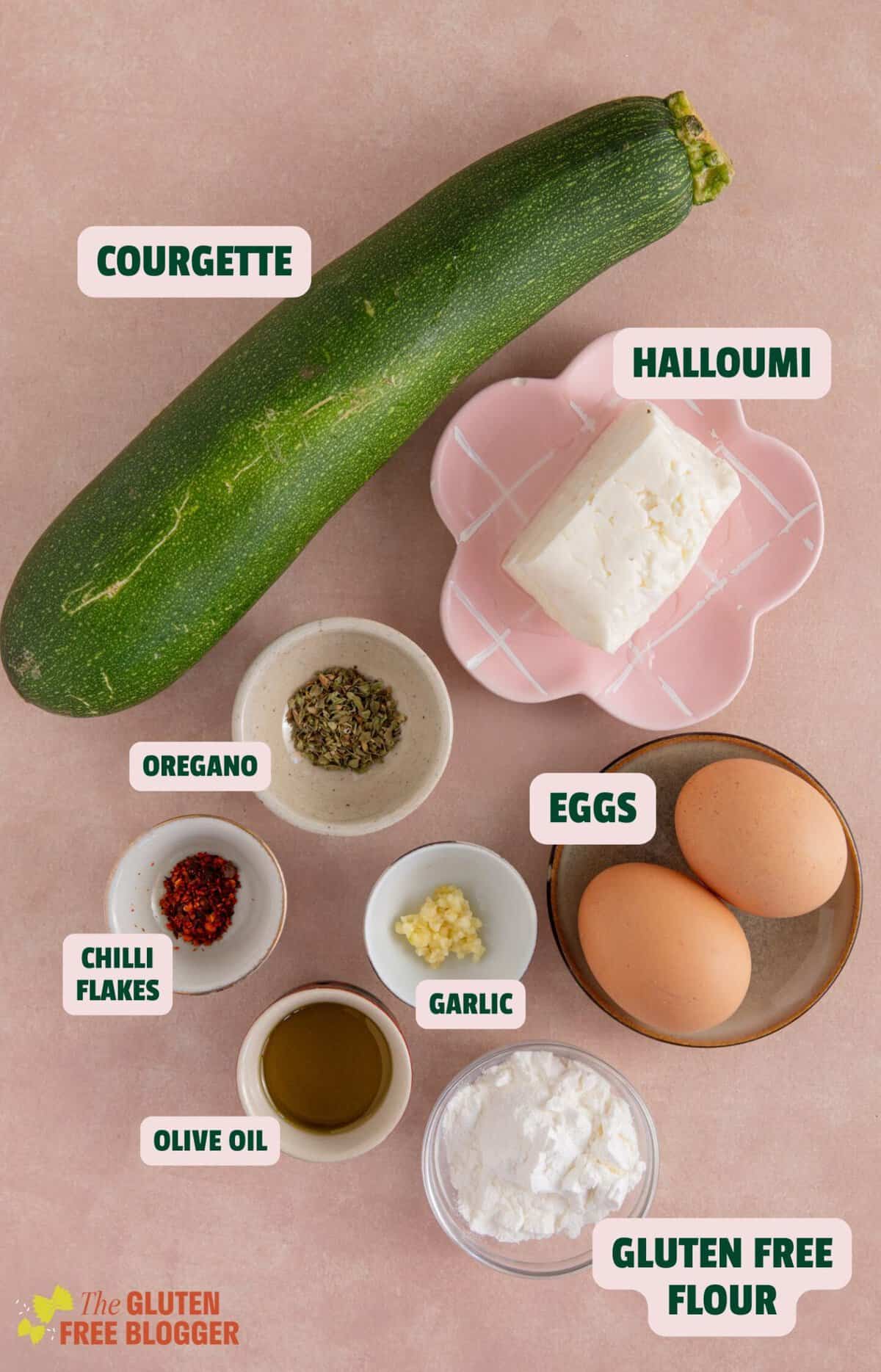 Ingredients for courgette and halloumi fritters laid out on a worktop with text labels.
