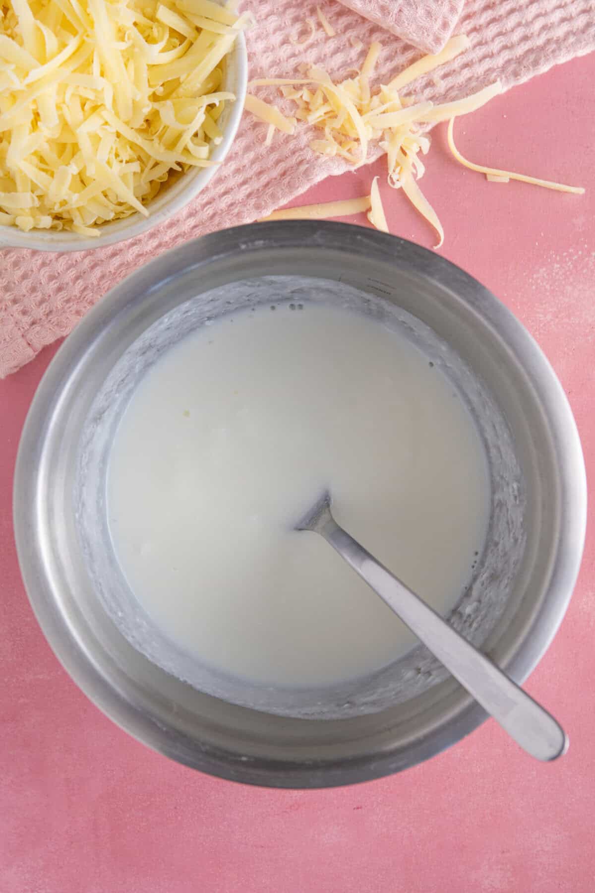 Process shot of gluten free cheese bread rolls showing a bowl with homemade buttermilk.
