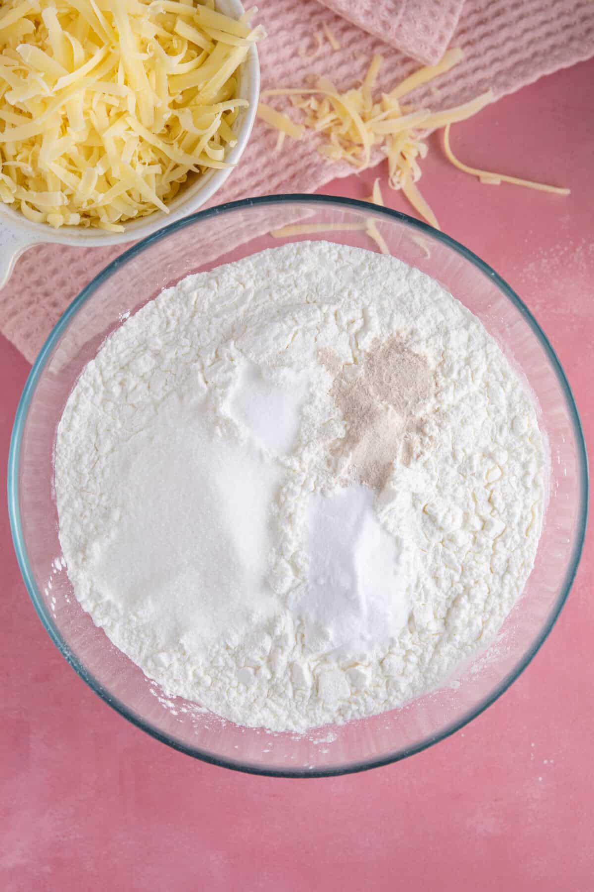 Process shot of gluten free cheese bread rolls showing the dry ingredients in a mixing bowl.