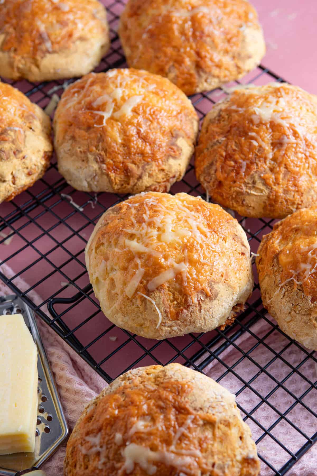 Cheese bread rolls on a cooling rack.