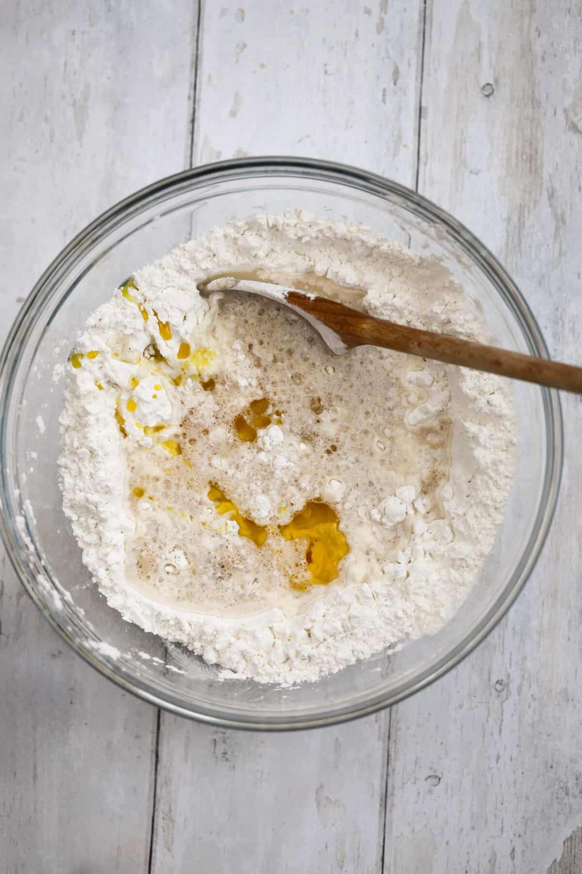 Process shot of 5-ingredient gluten free bread recipe showing the wet ingredients added to the flour.